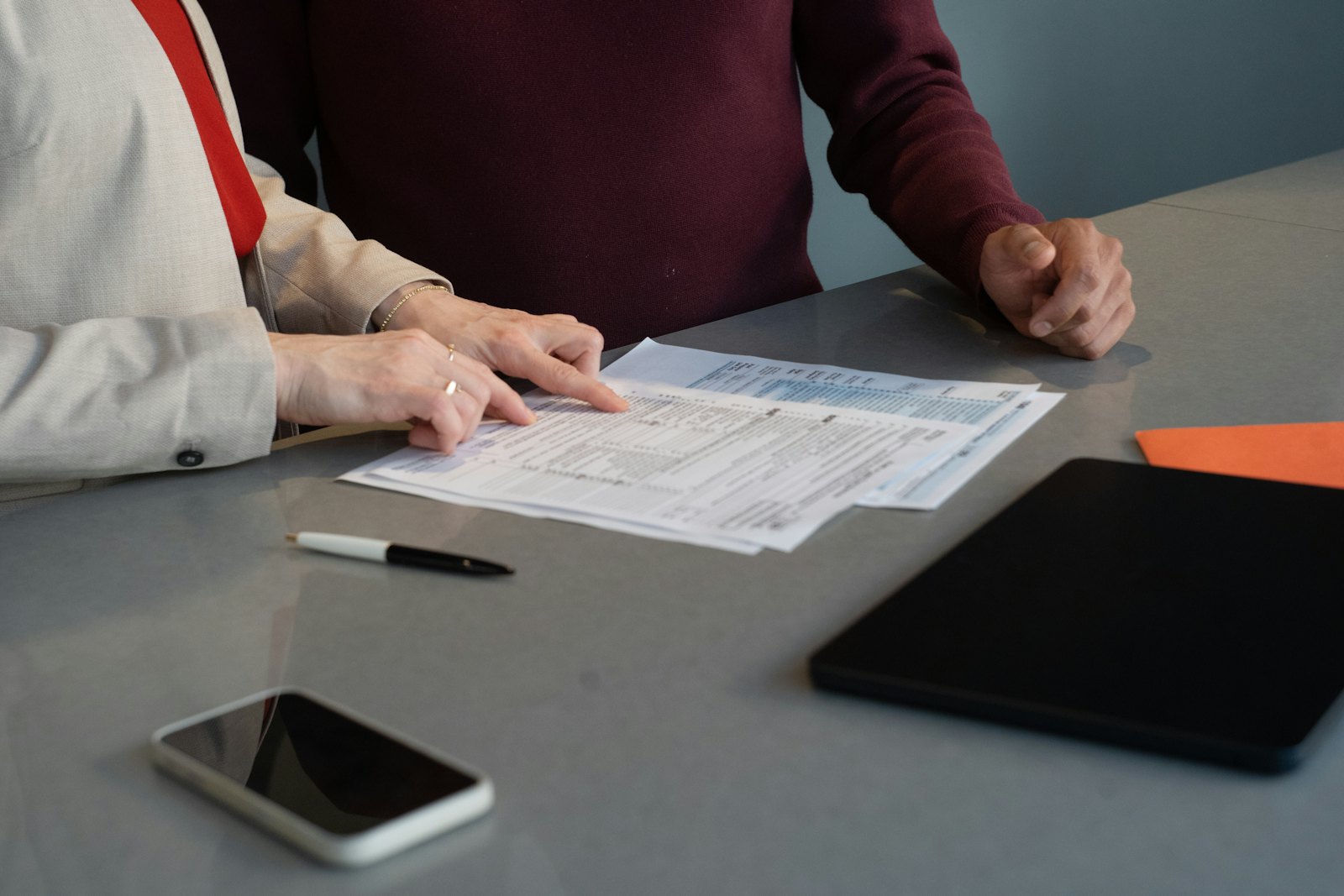A debt counsellor and an employee reviewing a credit report in a private clinic room